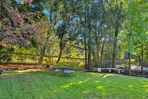 a view of a chairs and table in backyard of the house