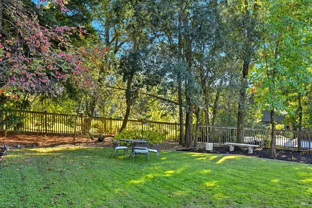 a view of a chairs and table in backyard of the house