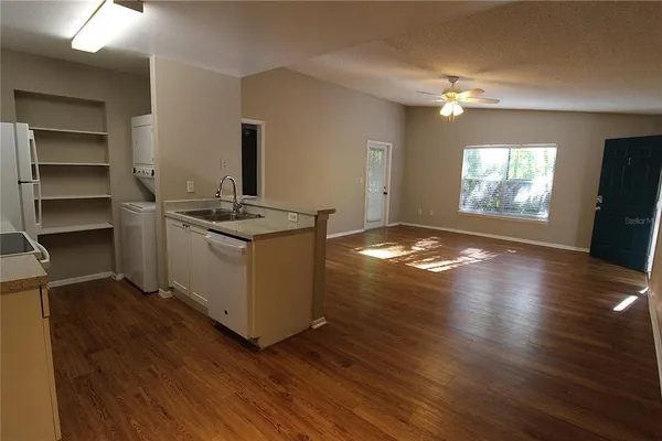 a view of kitchen and hall with wooden floor