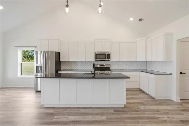 a view of kitchen with wooden floor electronic appliances and window