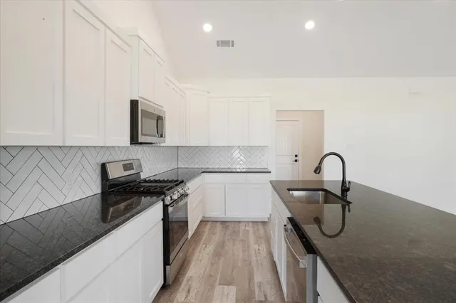 a view of kitchen with granite countertop cabinets and wooden floor