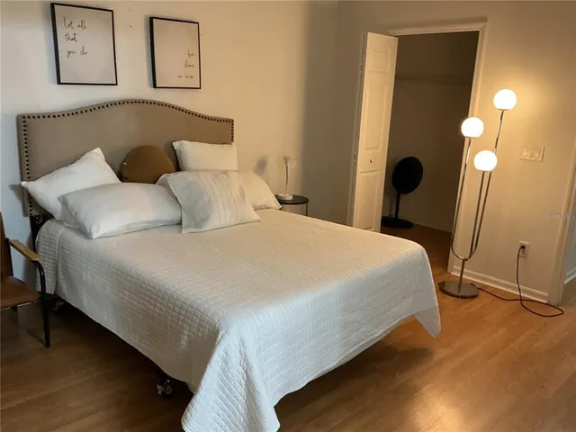 a bedroom with bed and painting on the wall