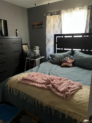 a bedroom with a bed and a window