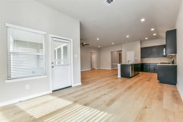 a view of kitchen with kitchen island a sink wooden floor and a refrigerator