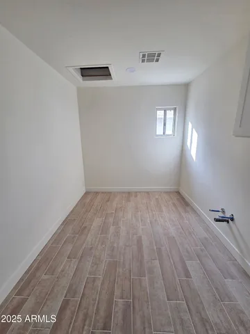 an empty room with a ceiling fan and window