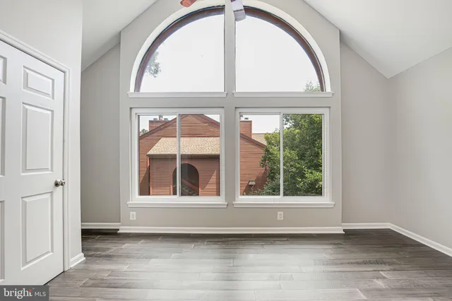 an empty room with wooden floor and a window