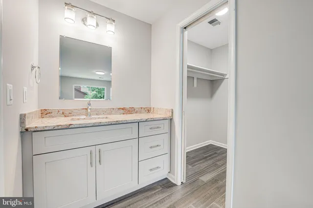 a bathroom with a granite countertop sink and a mirror