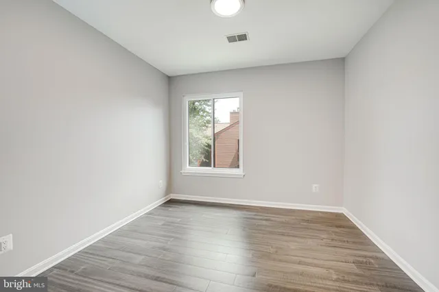 wooden floor in an empty room with a window