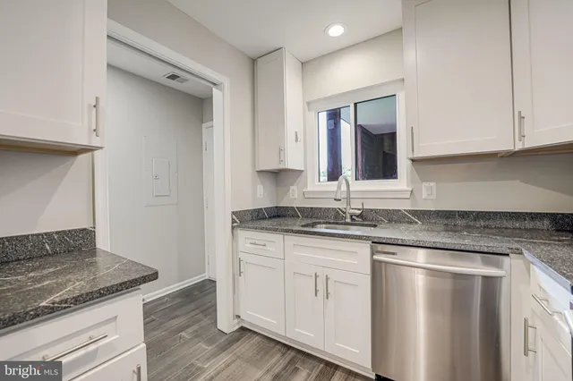 a kitchen with granite countertop a sink and cabinets
