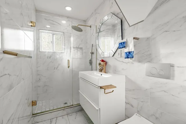 a bathroom with a sink a toilet and shower