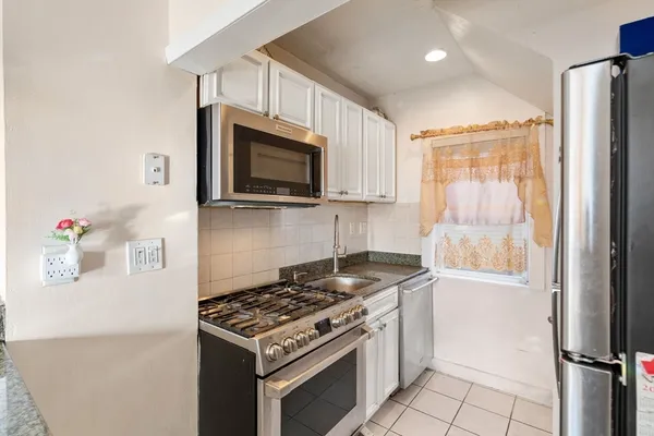 a kitchen with stainless steel appliances granite countertop a stove a microwave and a refrigerator