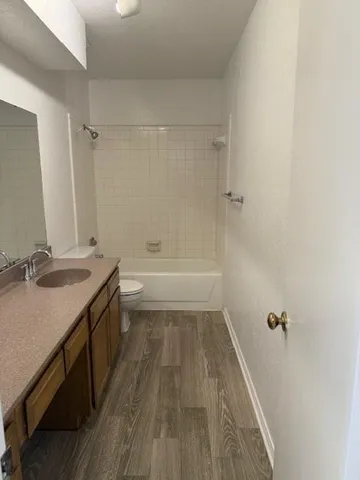 a bathroom with a granite countertop sink toilet and shower
