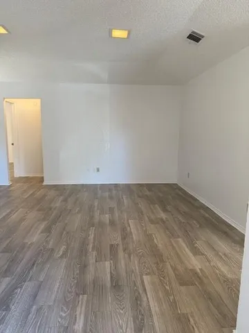 a view of room with wooden floor and white walls