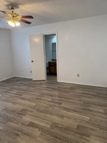 a view of a room with wooden floor and ceiling fan