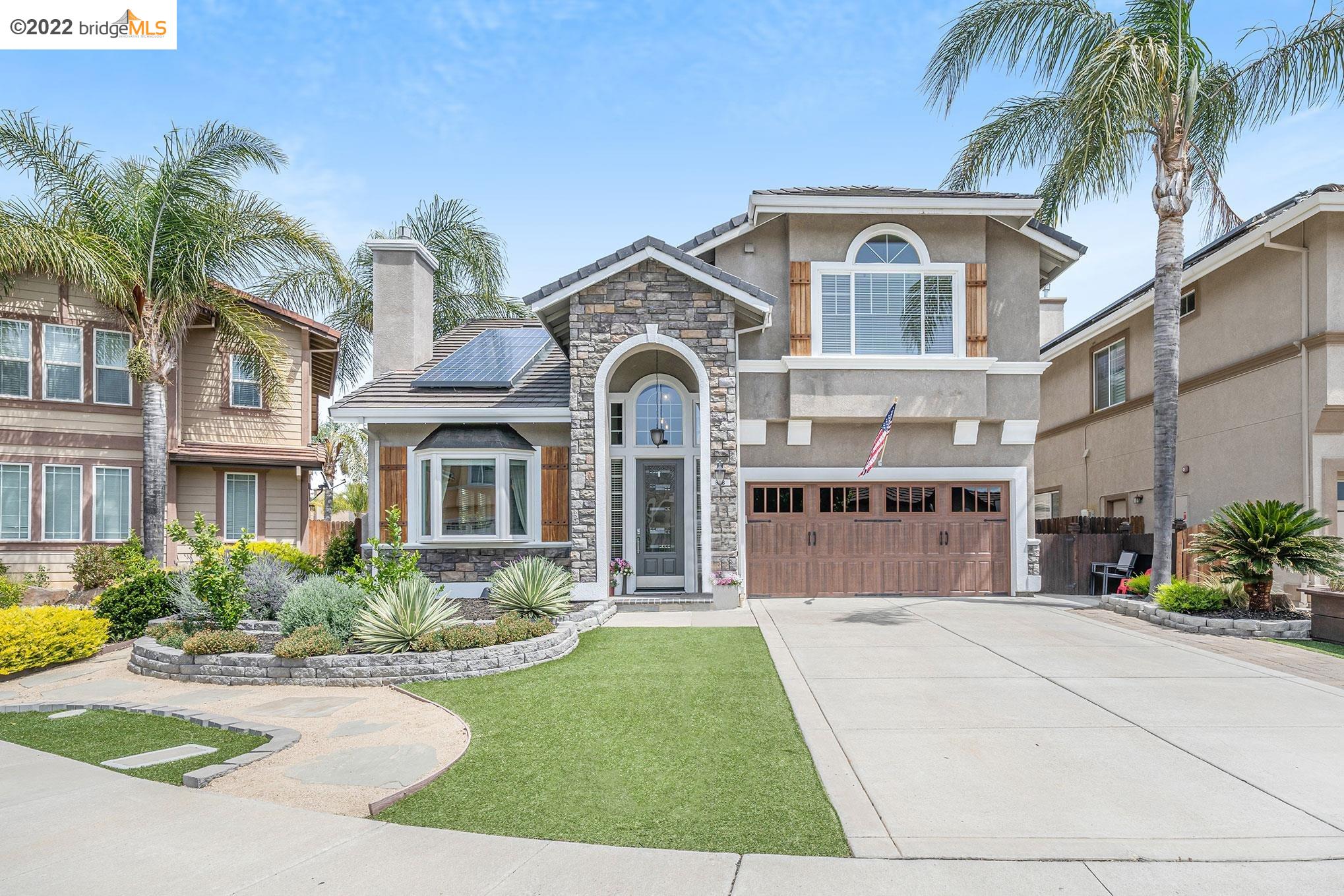 a front view of a house with a yard and potted plants