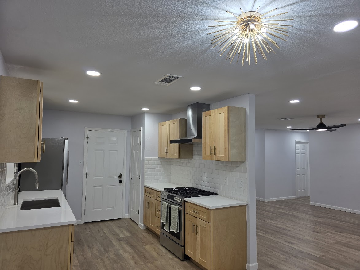 4803 Peach Grove Road Austin, TX 78744 - Photo 18 of 22 a kitchen with stainless steel appliances granite countertop a stove a refrigerator a sink and a microwave