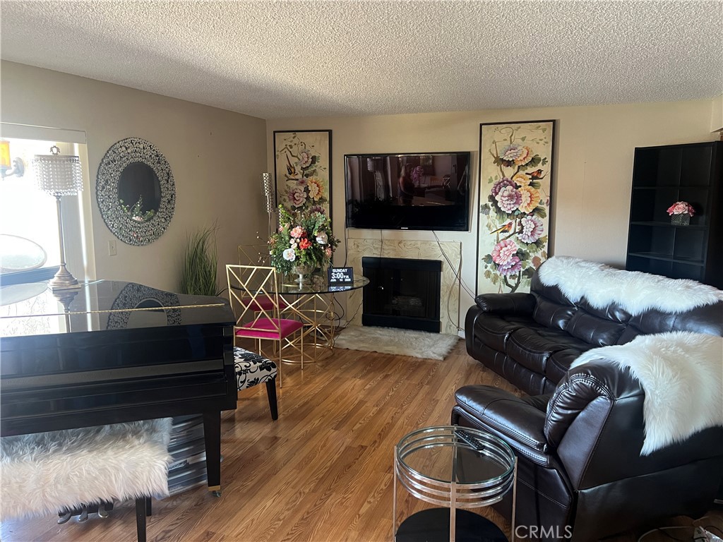 12300 Montecito Road, Unit 24 Seal Beach, CA 90740 - Photo 2 of 8 a living room with furniture a flat screen tv and a fireplace