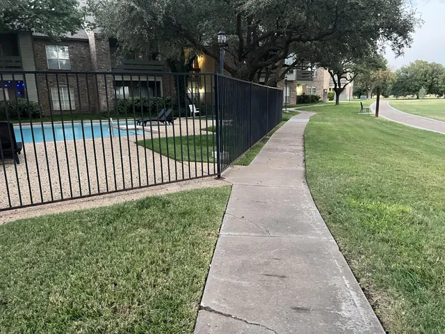 a view of a backyard with wooden fence