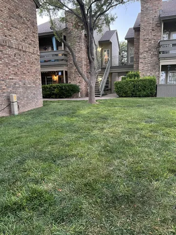 a view of a brick house with a yard