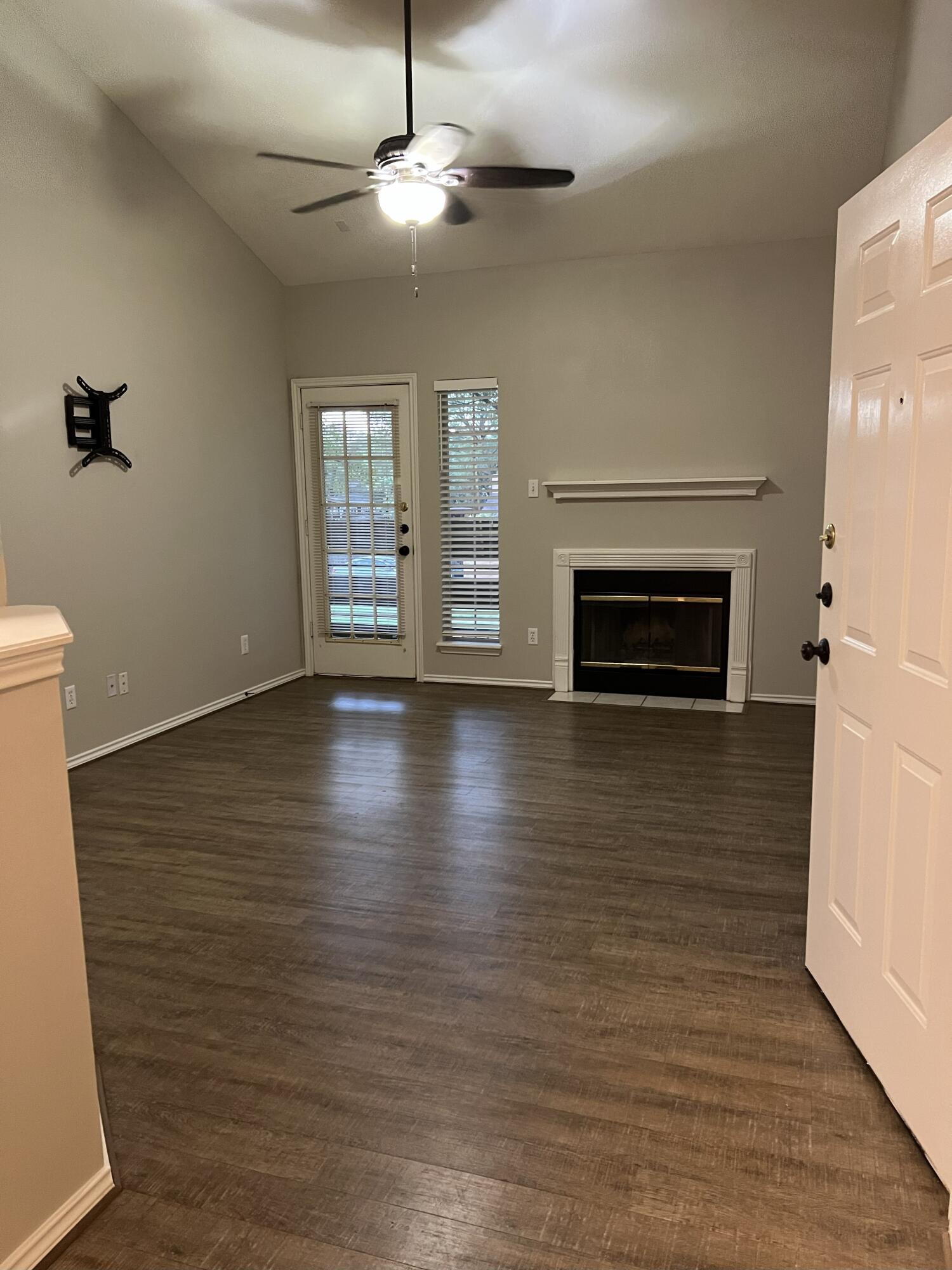5102 80th Street Lubbock, TX 79424 - Photo 4 of 20 an empty room with wooden floor fireplace and windows