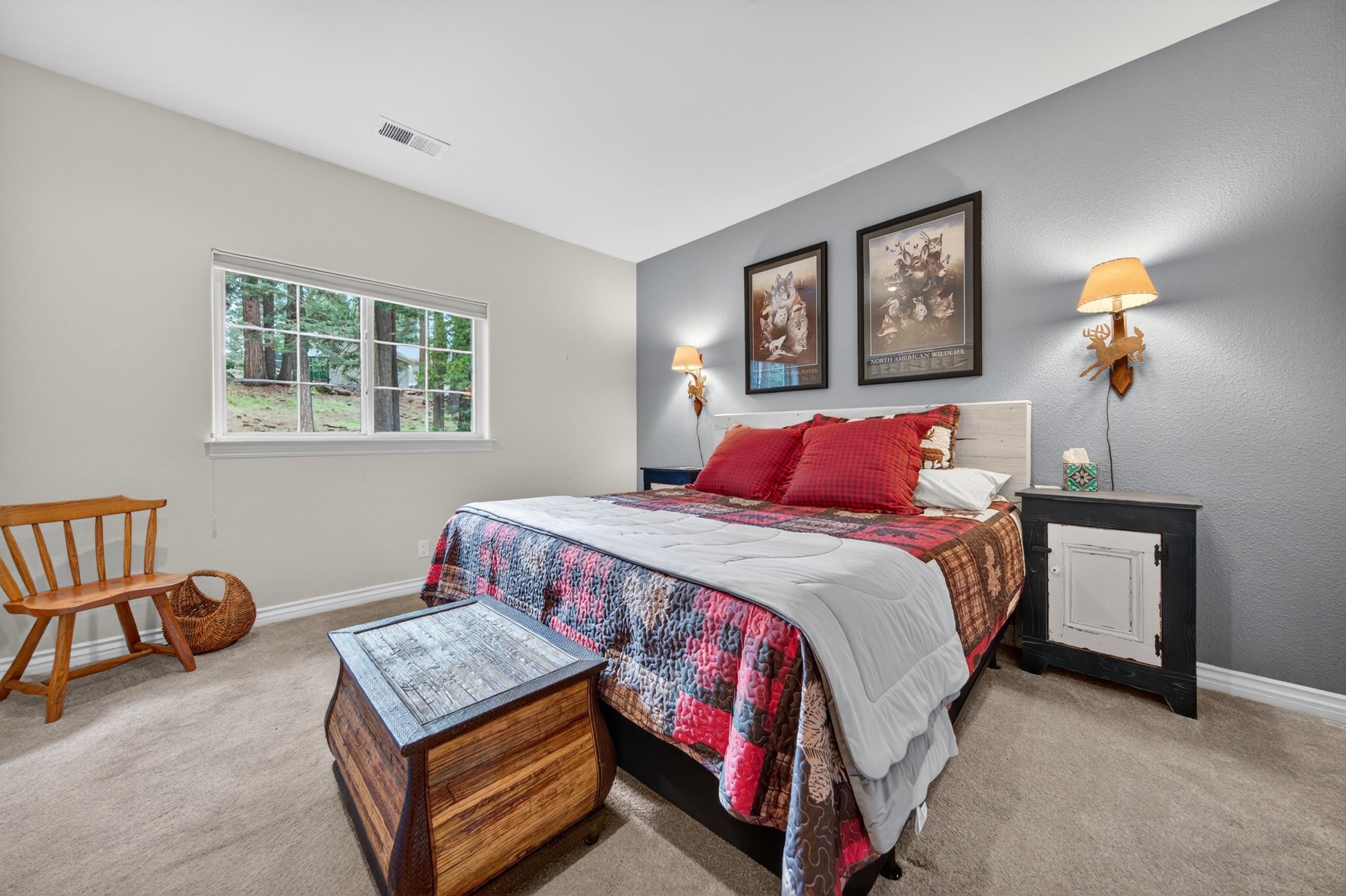1017 Timber Ridge Road Lake Almanor, CA 96137 - Photo 21 of 45 a bedroom with a bed and a lamp with window