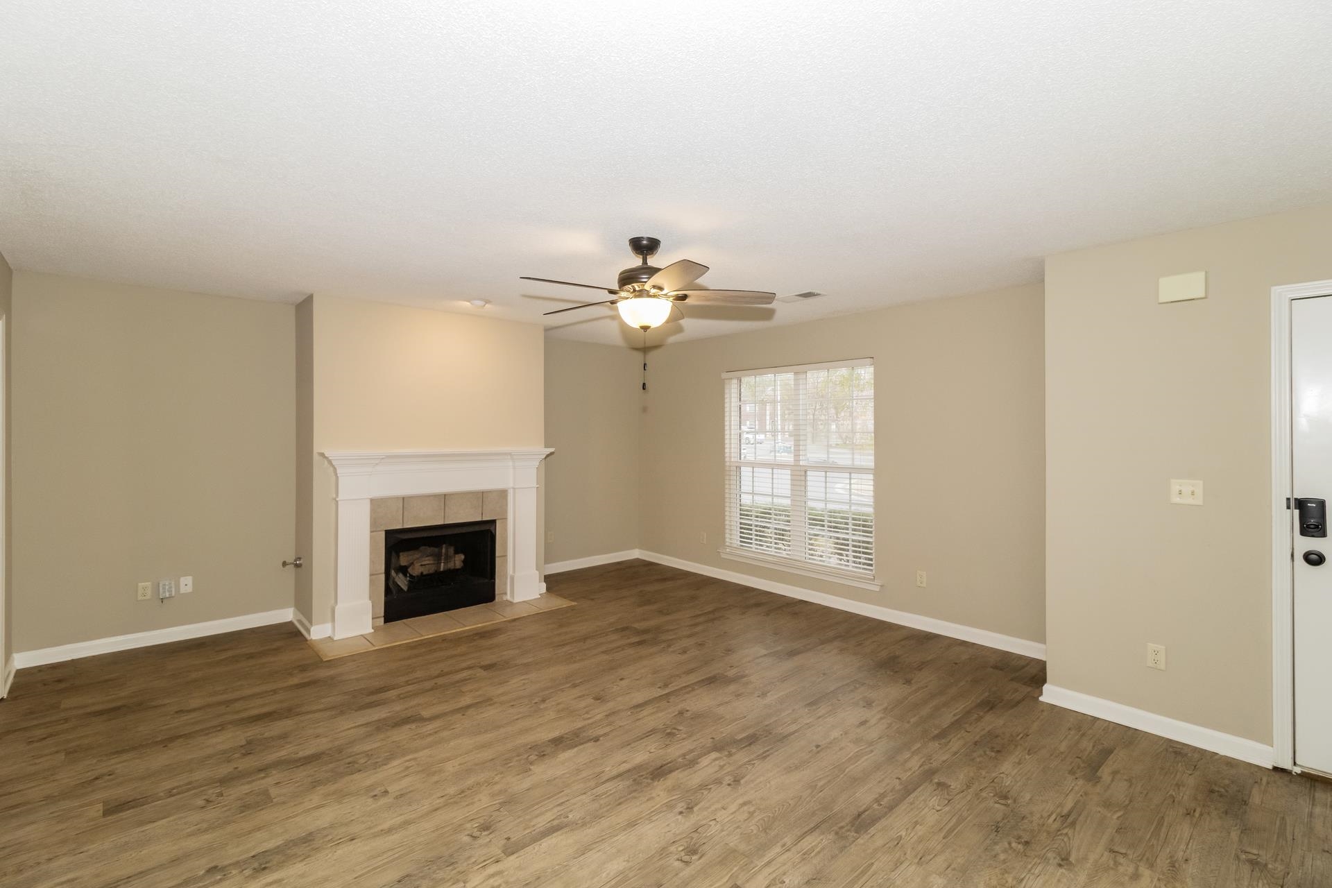 5368 Milton Ridge Drive Arlington, TN 38002 - Photo 4 of 17 Unfurnished living room featuring wood finished floors, a tile fireplace, and a ceiling fan