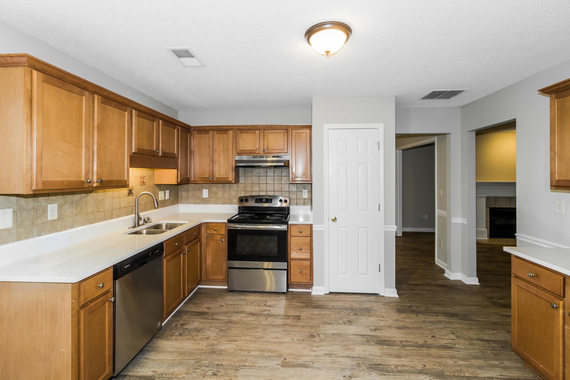5368 Milton Ridge Drive Arlington, TN 38002 - Photo 6 of 17 Kitchen with stainless steel appliances, backsplash, dark wood-style floors, and brown cabinetry