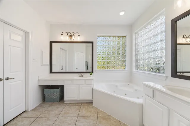 a spacious bathroom with a tub a sink and a window