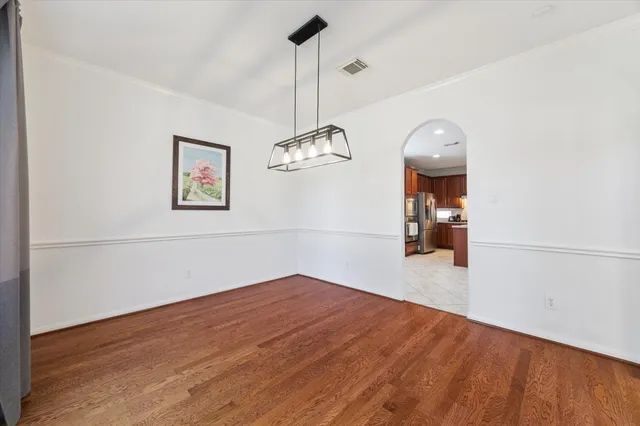 a view of a room with wooden floor and ceiling fan