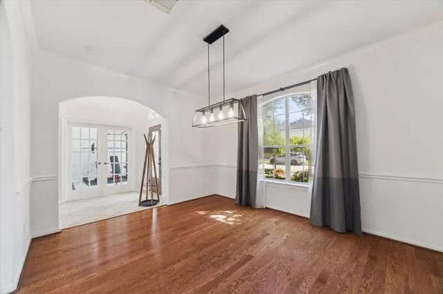 a view of an empty room with window and wooden floor