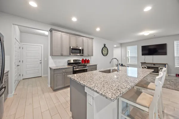 a kitchen with microwave a stove and cabinets
