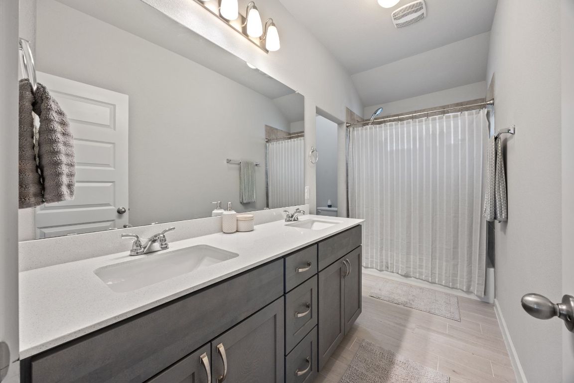 161 Appleberry Lane Elgin, TX 78621 - Photo 28 of 40 Secondary bathroom, upstairs. Dual vanity, *window at the shower, tucked away WC area.