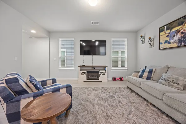 a living room with furniture a fireplace and a flat screen tv