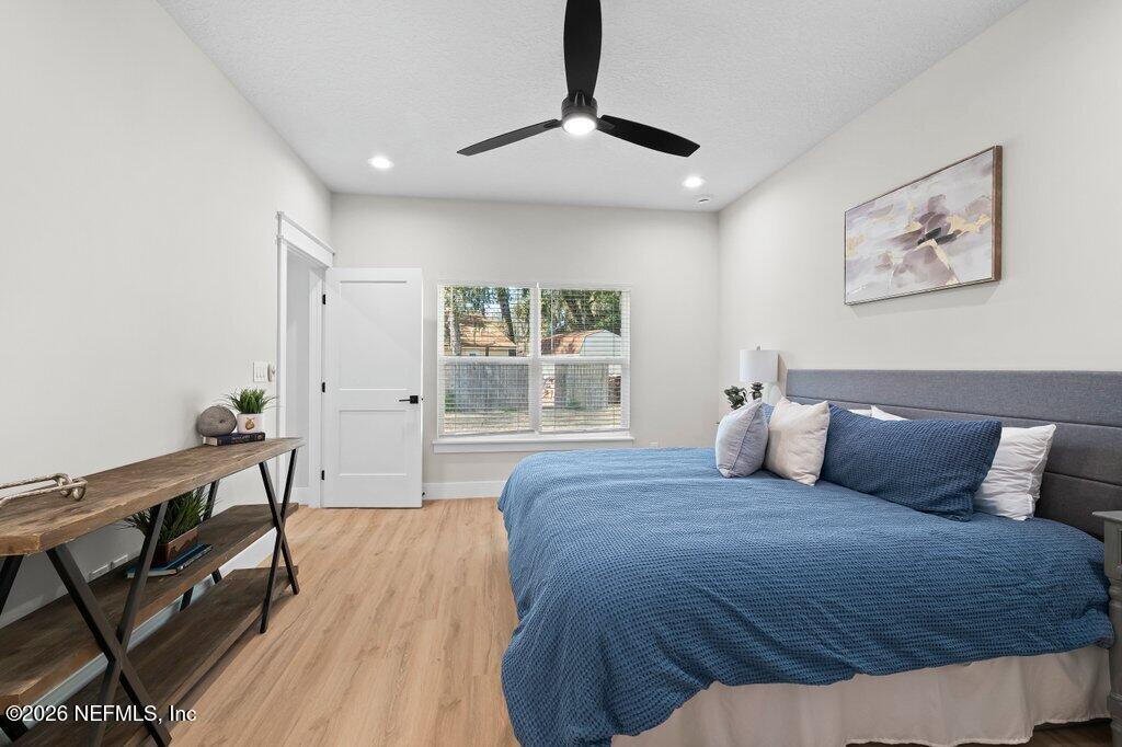 9019 Hipps Road Jacksonville, FL 32222 - Photo 31 of 35 a spacious bedroom with a bed and a chandelier