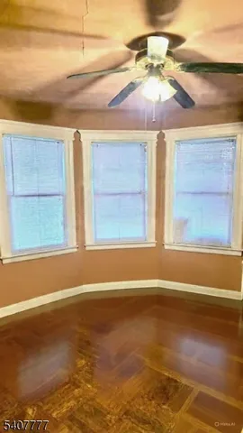 a view of a room with wooden floor and fan
