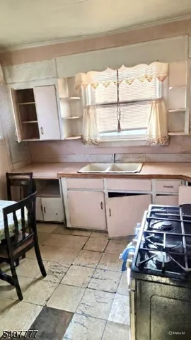 a kitchen with a stove a sink and a table