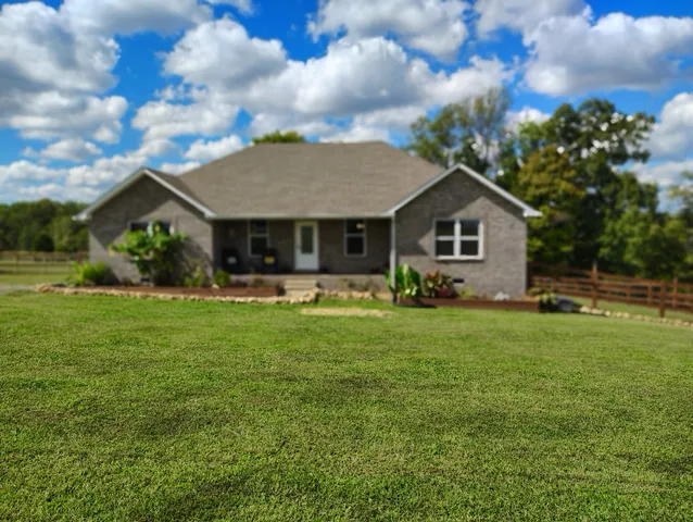 a front view of house with yard and green space