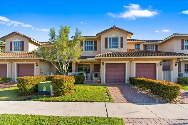 a front view of a house with a yard and potted plants