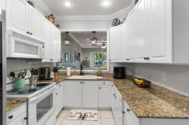 a kitchen with stainless steel appliances granite countertop a sink stove and cabinets