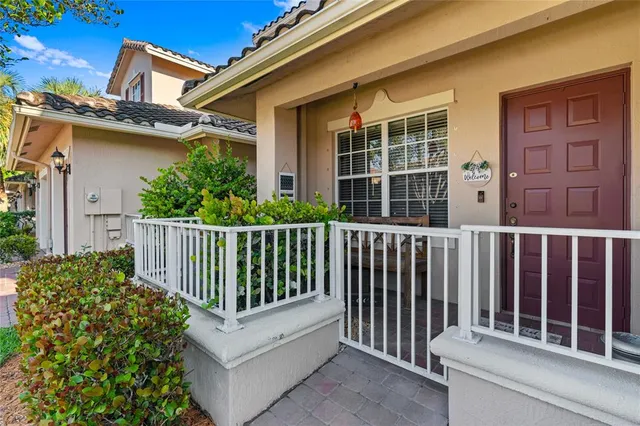 a view of a porch with a floor to ceiling window and potted plants