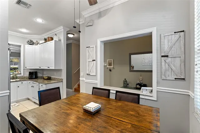 a kitchen with a table chairs refrigerator and microwave