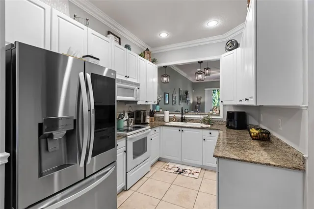 a kitchen with a sink stainless steel appliances and white cabinets