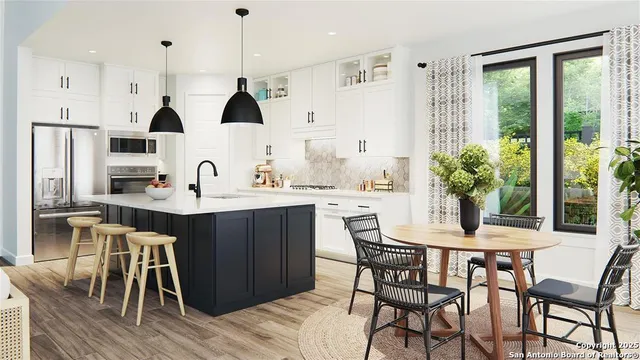 a kitchen with stainless steel appliances kitchen island granite countertop a table and chairs in it