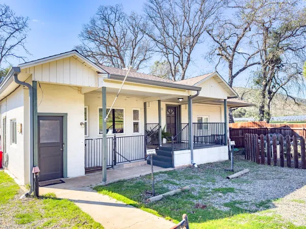 a view of a house with a yard and porch