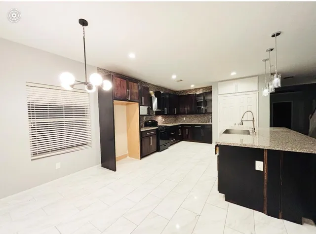 a kitchen with stainless steel appliances kitchen island sink refrigerator and cabinets