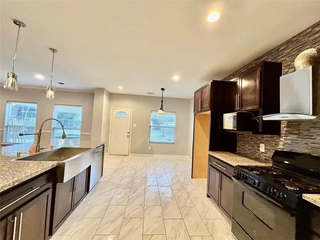a large kitchen with stainless steel appliances granite countertop a stove and a sink