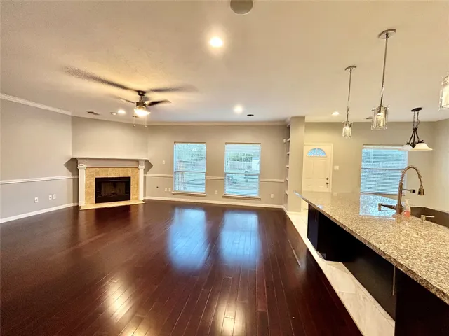 a view of a kitchen with kitchen island a sink wooden floor and a large window