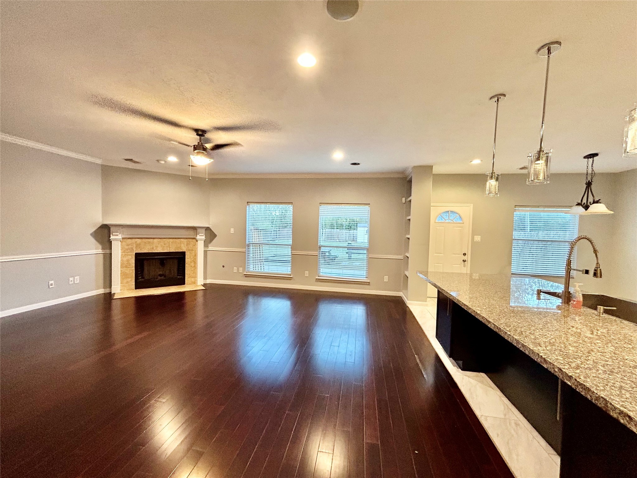 22918 Breton Point Drive Spring, TX 77373 - Photo 20 of 49 a view of a kitchen with kitchen island a sink wooden floor and a large window
