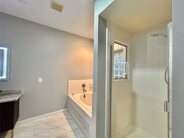 a bathroom with a tub shower and sink