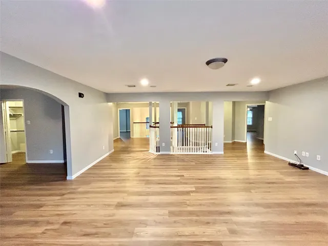 a view of a hallway with wooden floor and windows